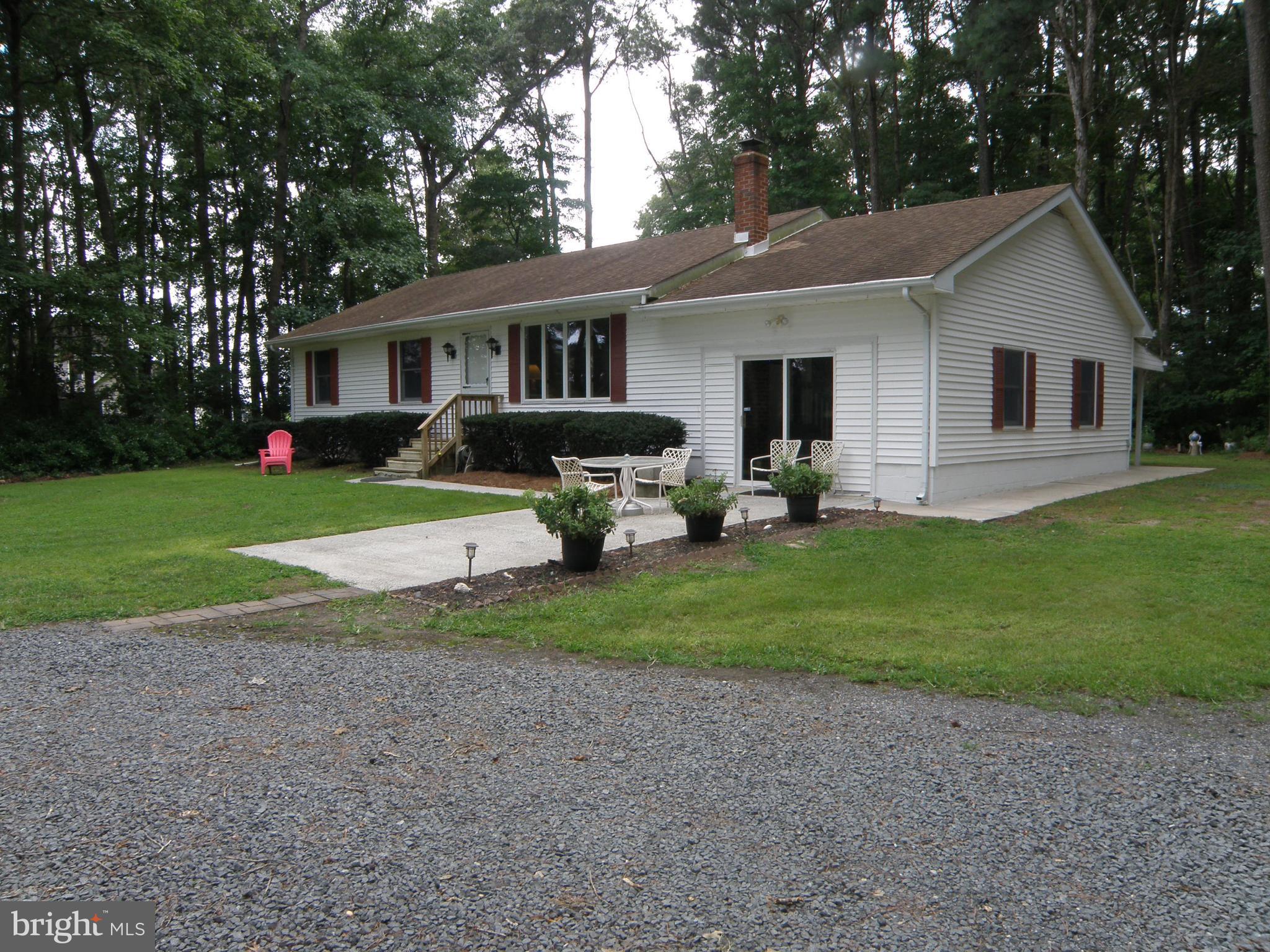 a front view of a house with a garden and trees