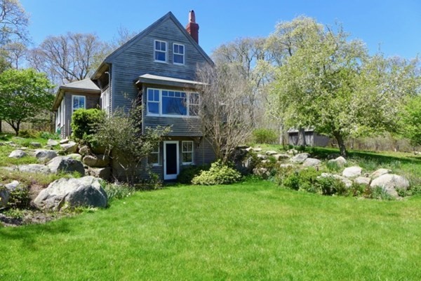 a front view of a house with a garden and plants