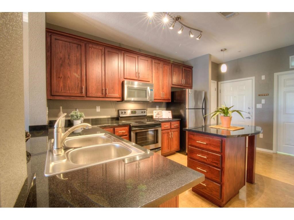 a kitchen with a refrigerator cabinets and wooden floor