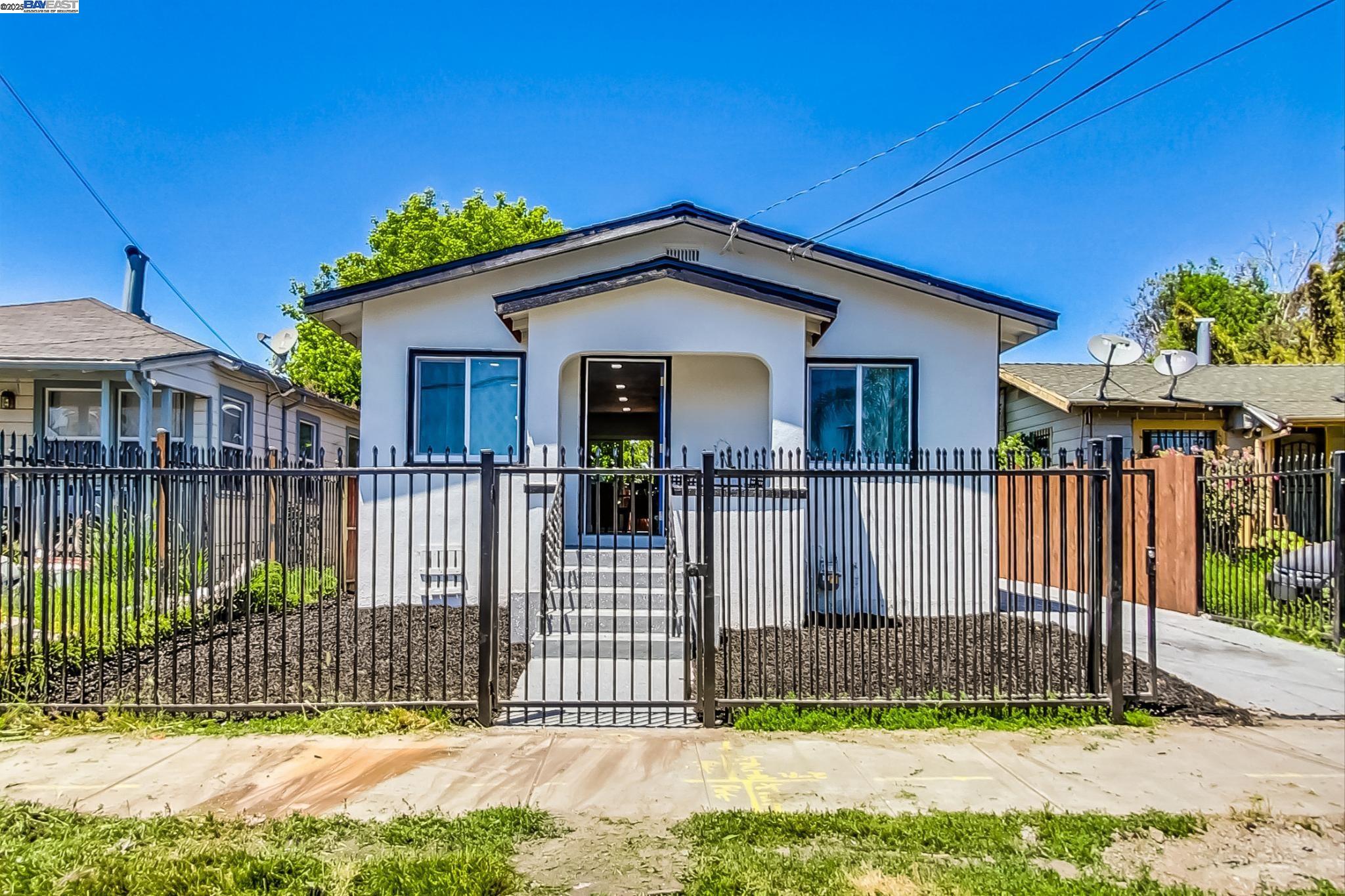 a view of a house with a small yard and wooden fence