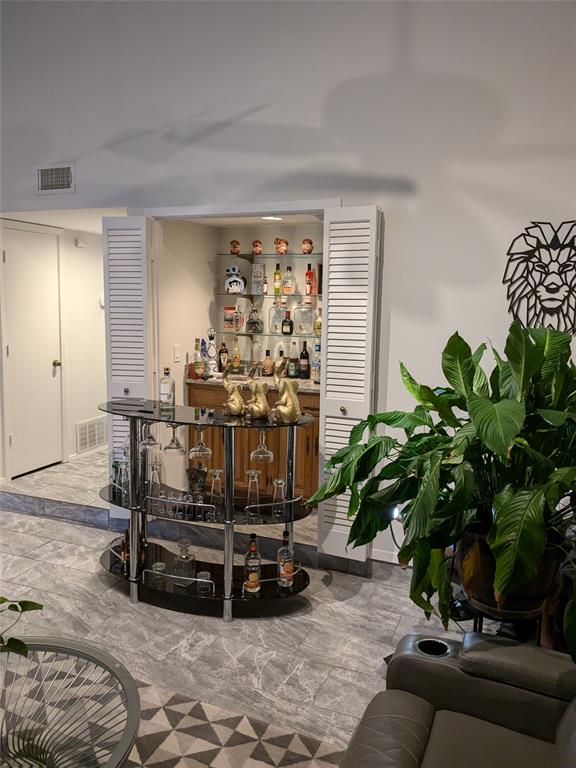 a living room with patio furniture and a potted plant