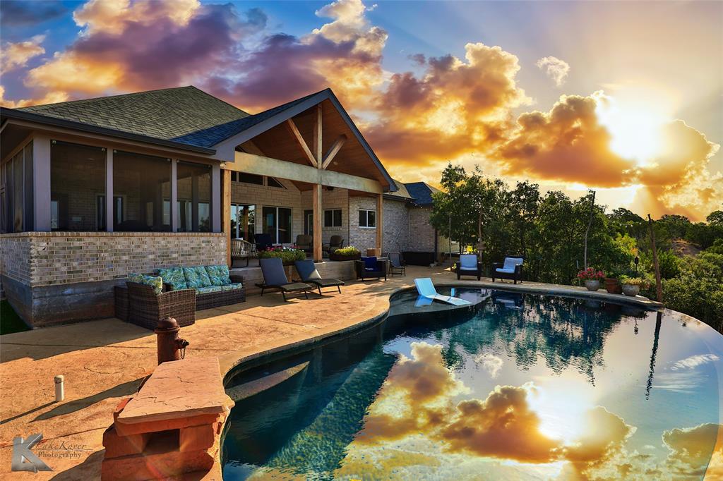 a view of house with swimming pool and a yard