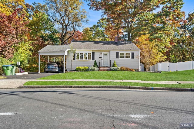 a front view of a house with a garden and trees