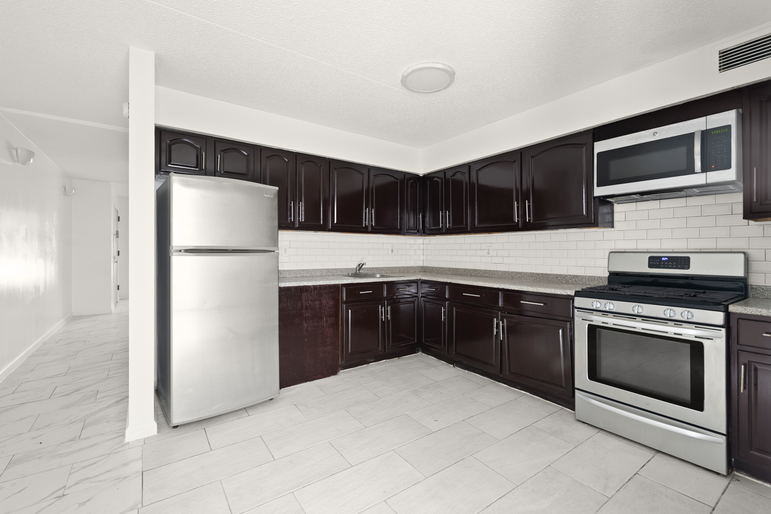 a kitchen with stainless steel appliances granite countertop a refrigerator and a stove top oven