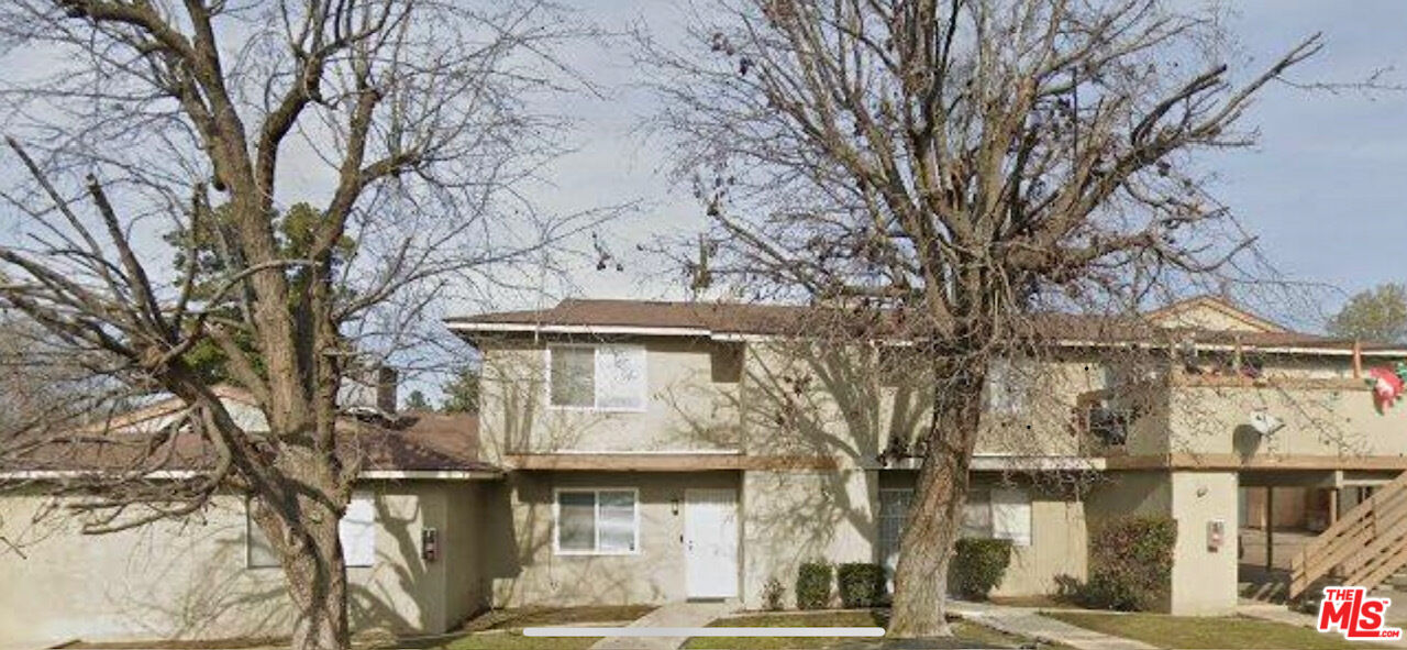 a front view of a building with large trees