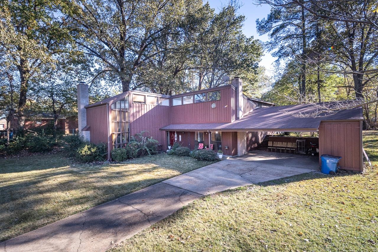 View of front facade with a carport and a front yard