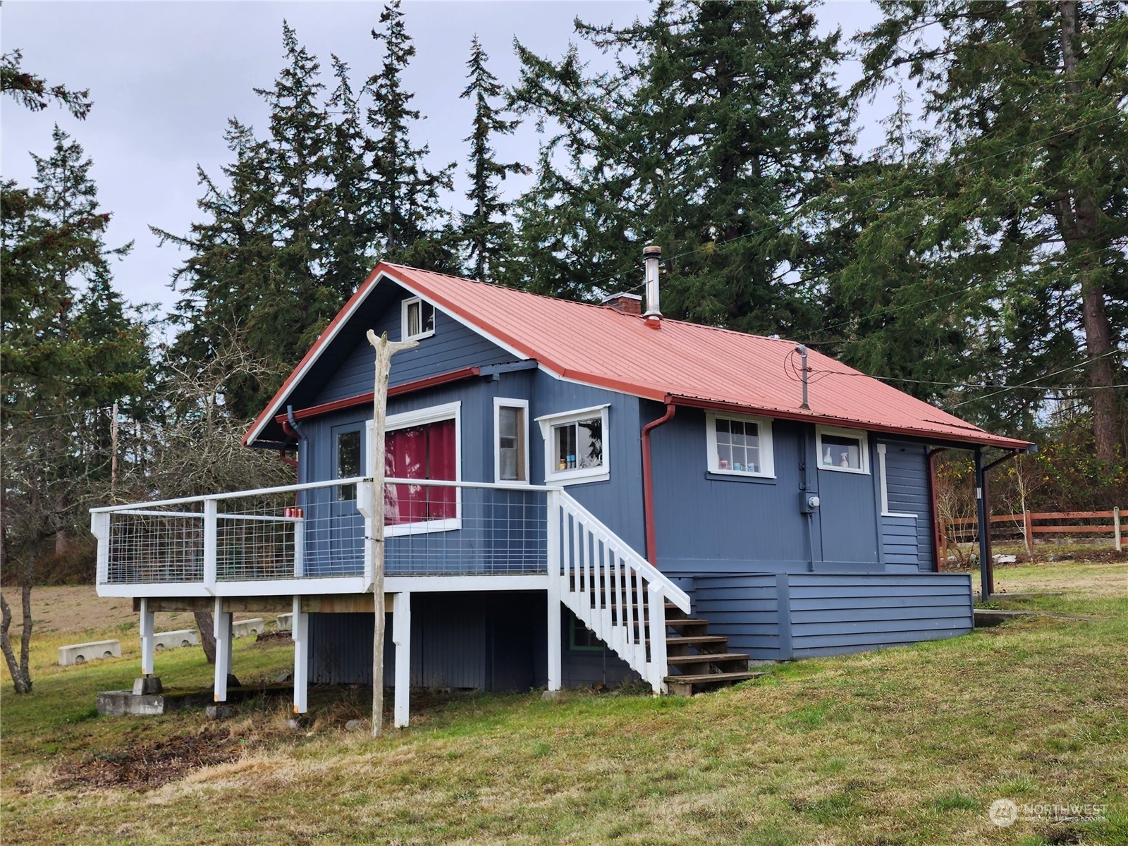 a view of a house with a yard balcony and wooden fence