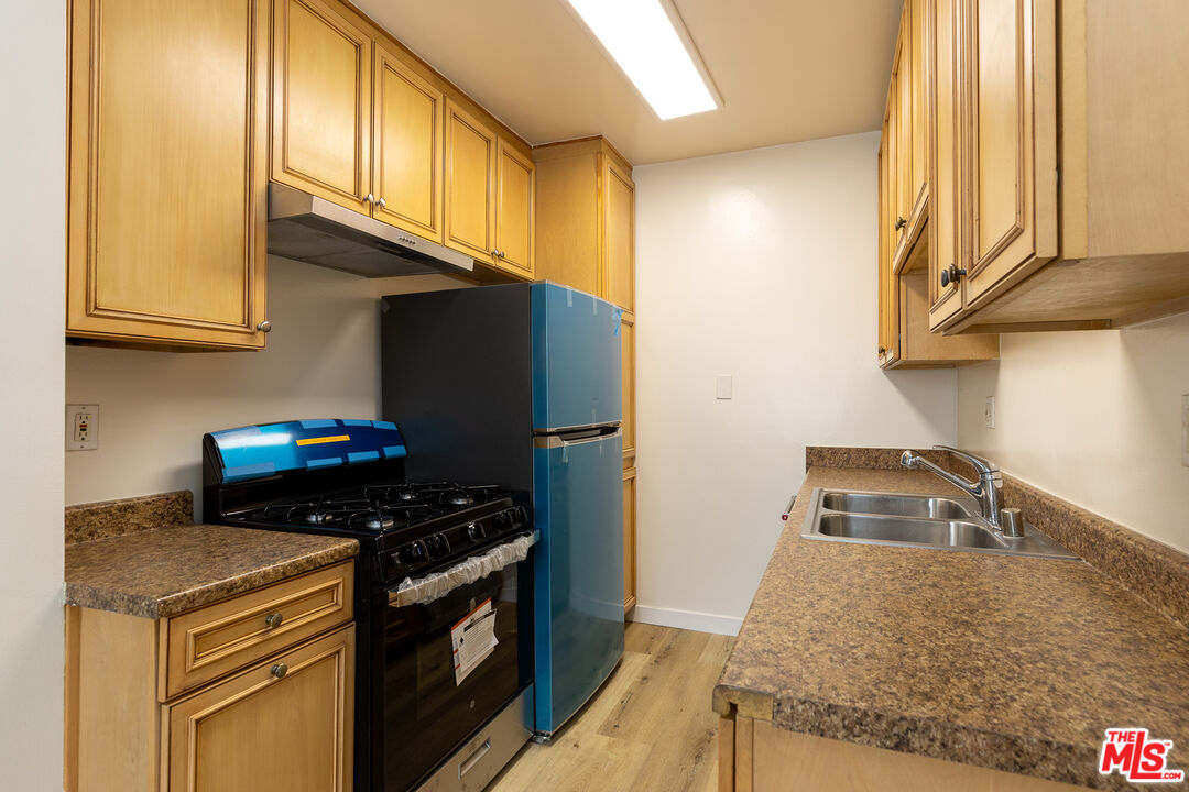 a kitchen with granite countertop a stove and a refrigerator