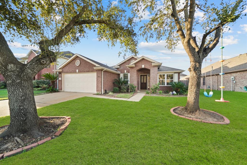 a front view of a house with a yard and tree