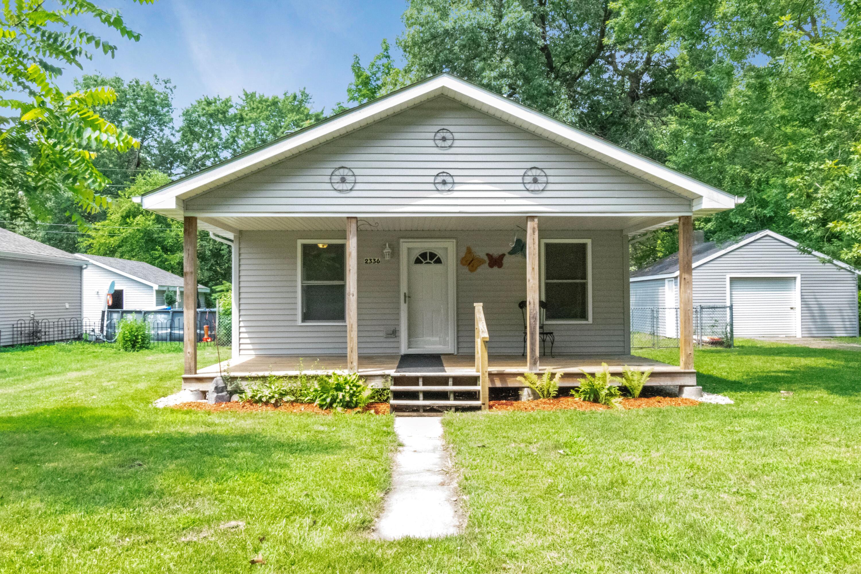 a backyard of a house with table and chairs