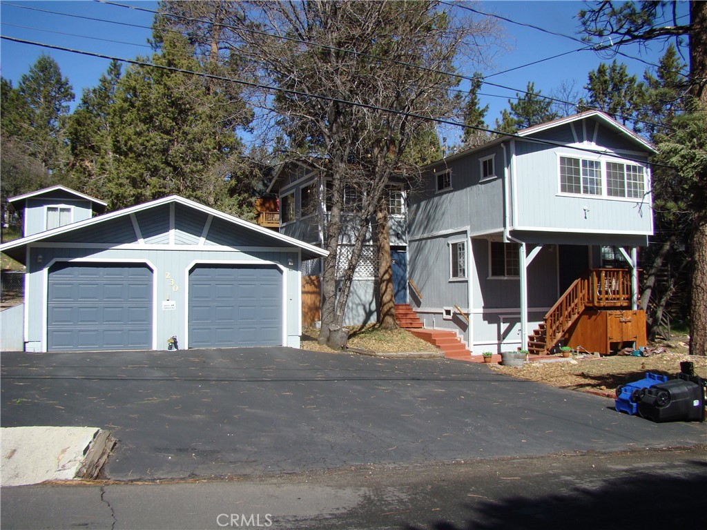 a view of a house with a yard and large tree