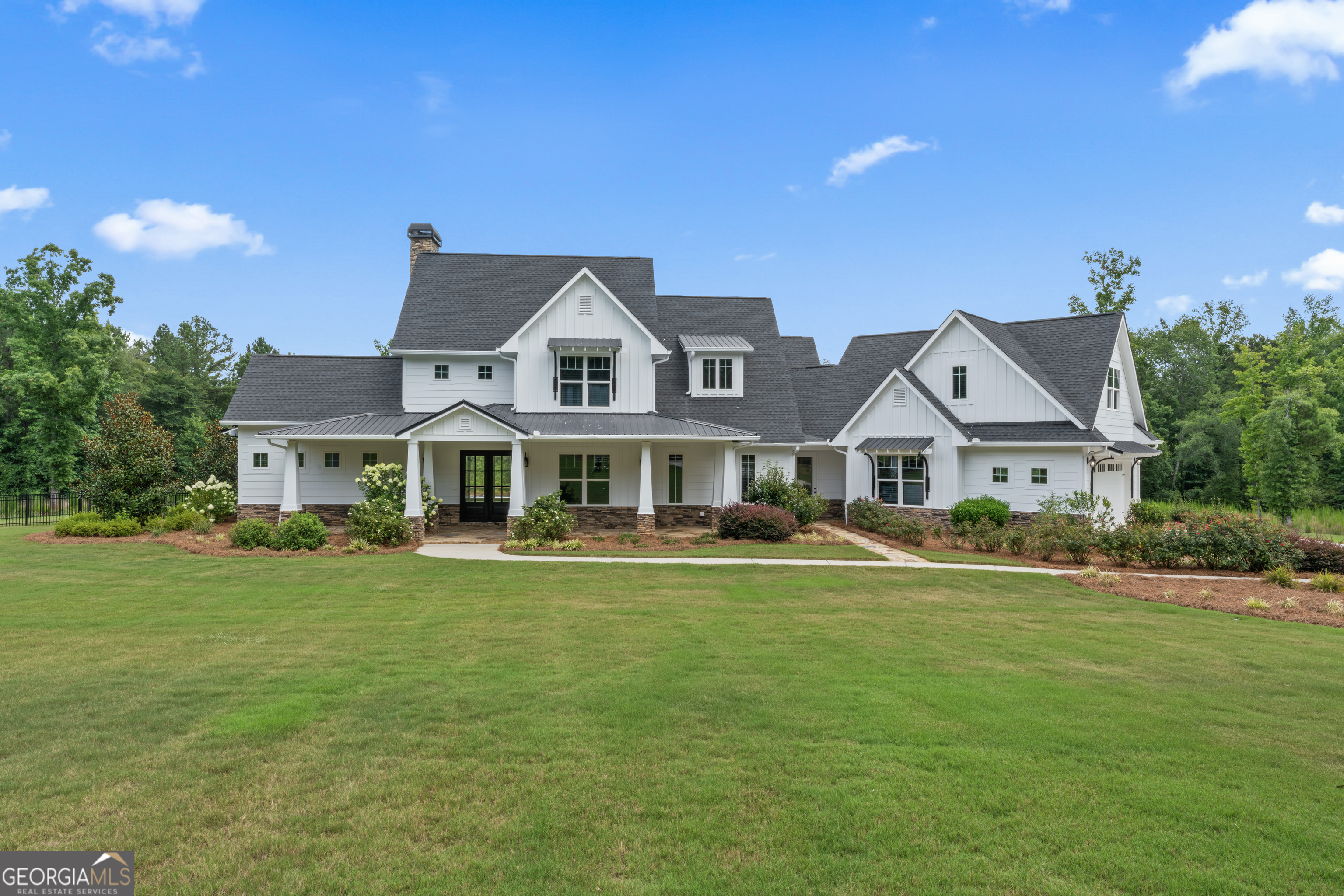 a front view of a house with a garden and yard