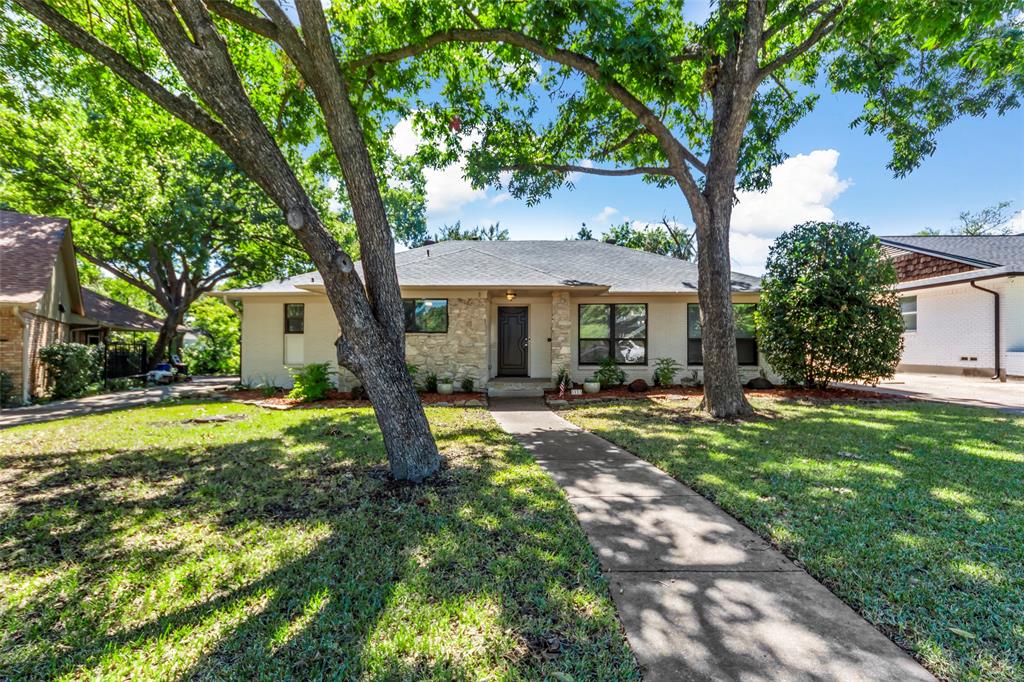 a view of a house with backyard and a tree