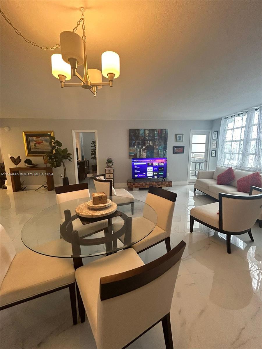 a living room with furniture a flat screen tv and kitchen view