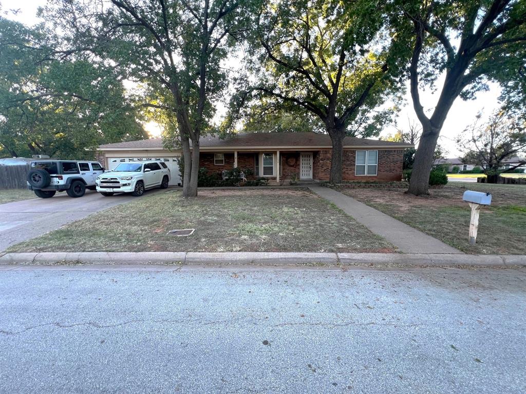 a view of a house with a large tree in front of it