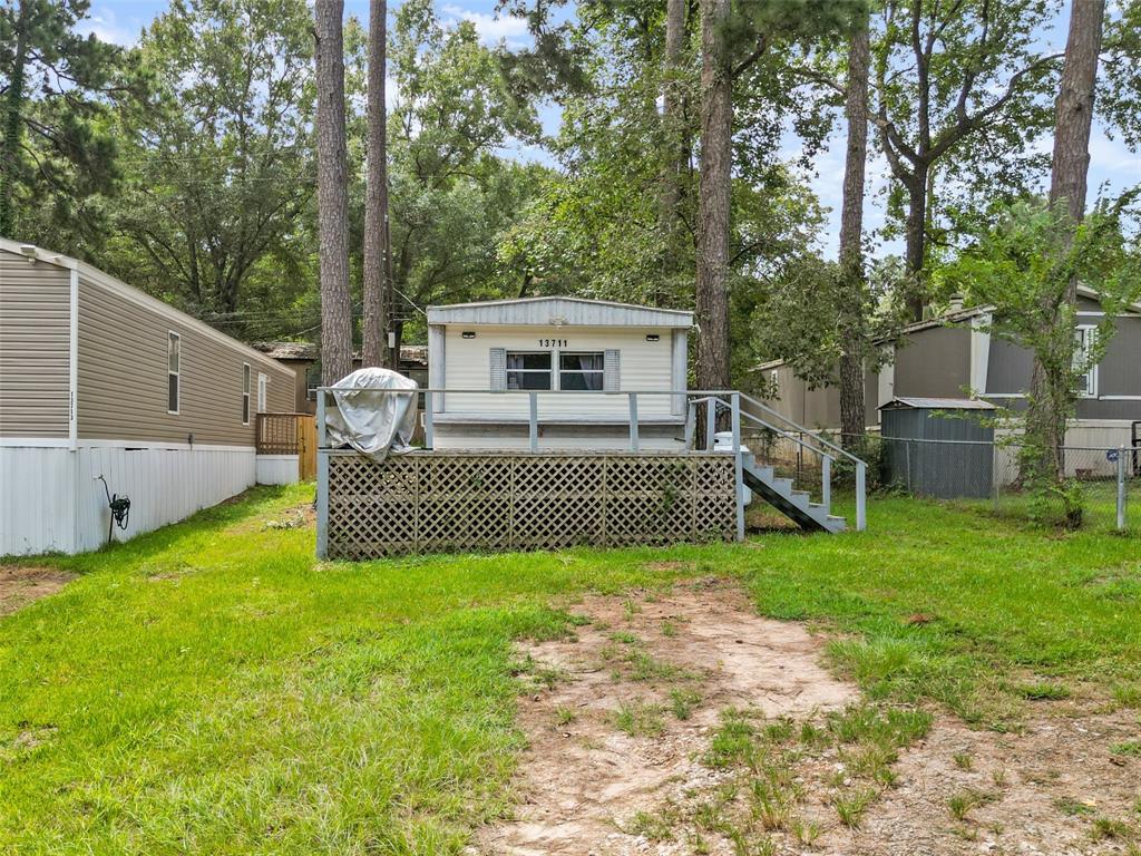 a view of a deck with large trees and a wooden fence