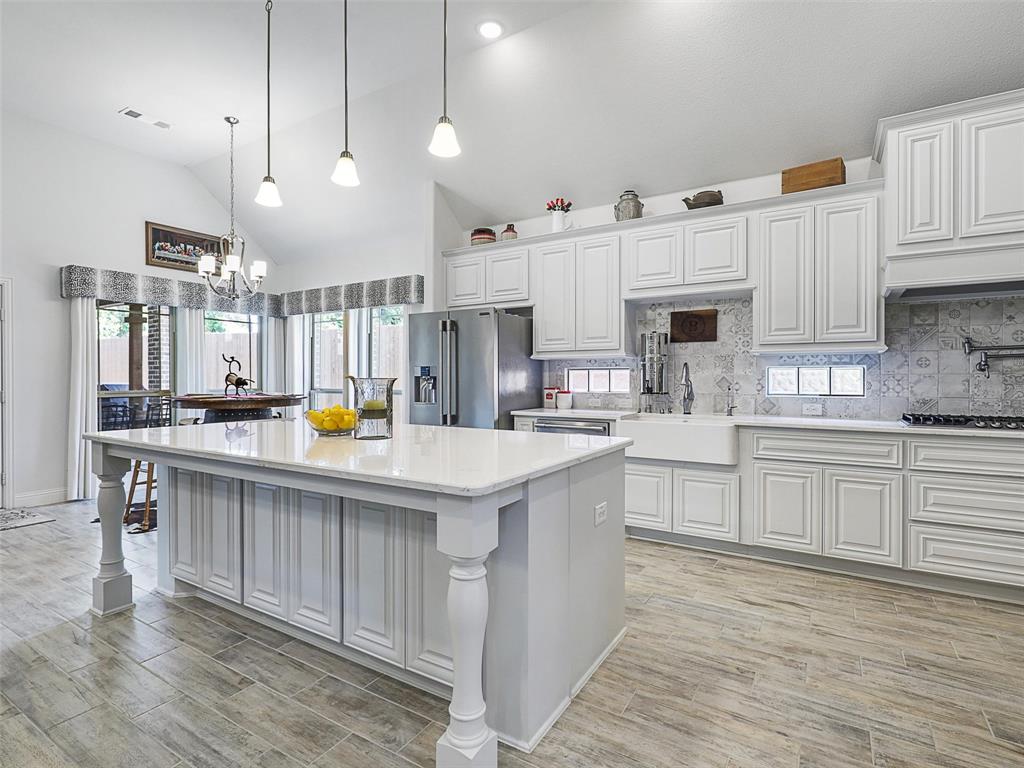 a kitchen with kitchen island granite countertop a sink cabinets and wooden floor