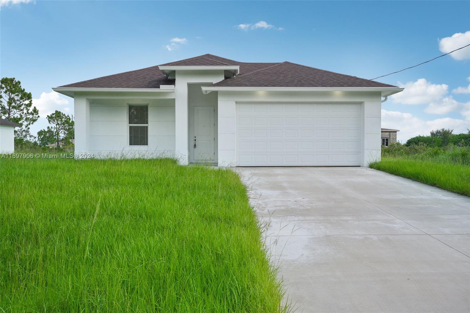 a front view of a house with yard and garage