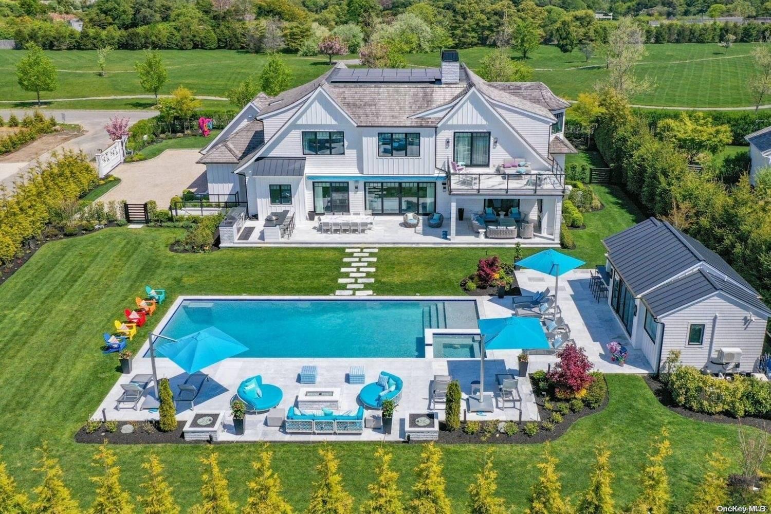 a view of a house with a big yard potted plants and a large pool