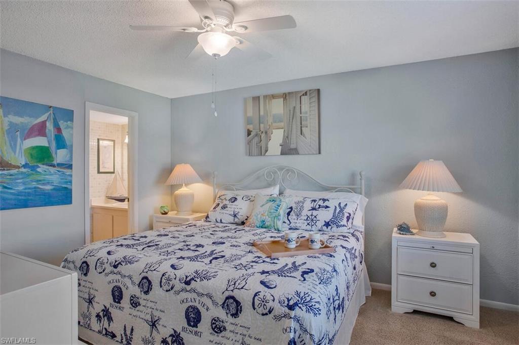 Carpeted bedroom with ceiling fan, a textured ceiling, and ensuite bathroom