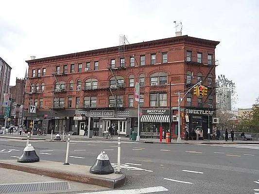 a view of a tall building next to a road