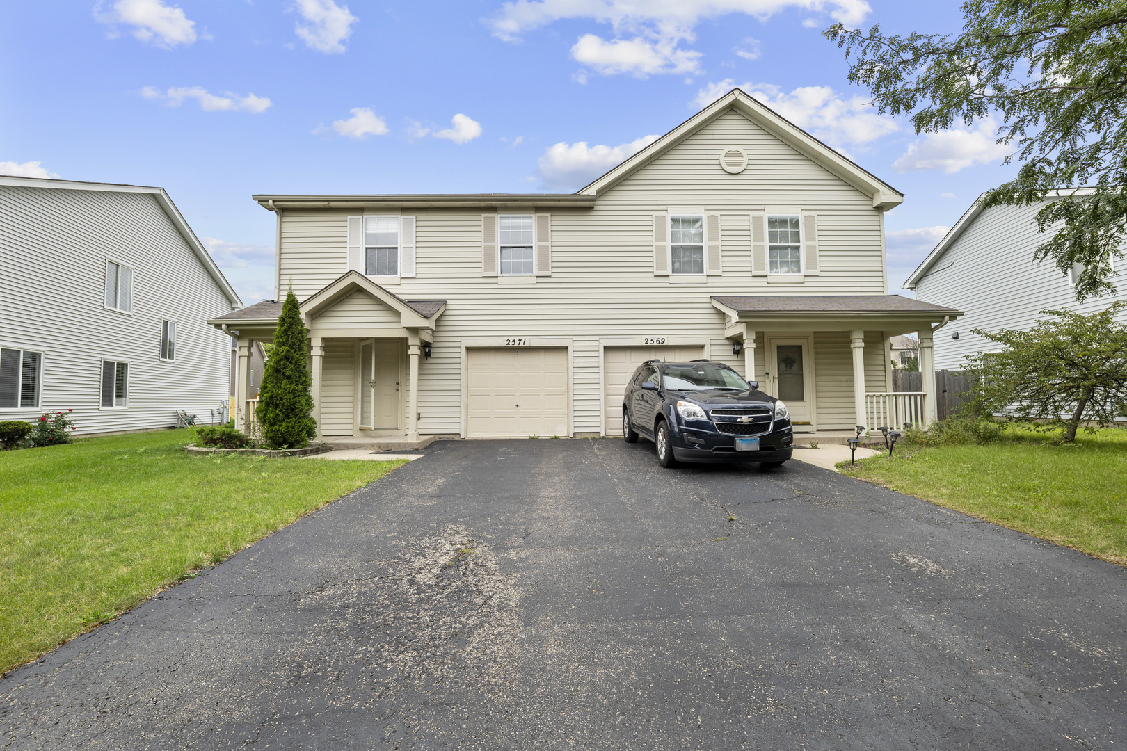 a front view of a house with a garden and parking