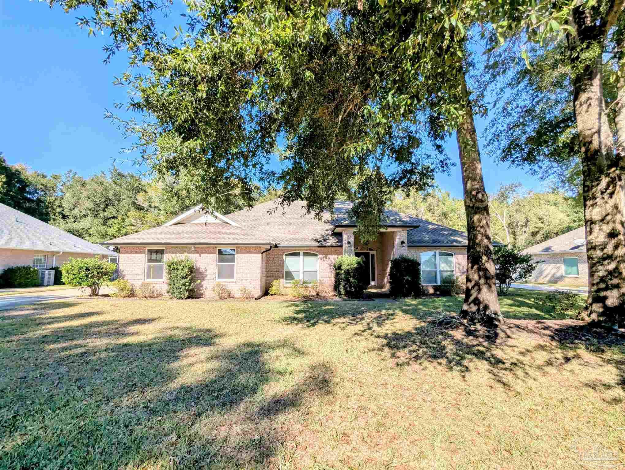 a view of a house with a yard and tree