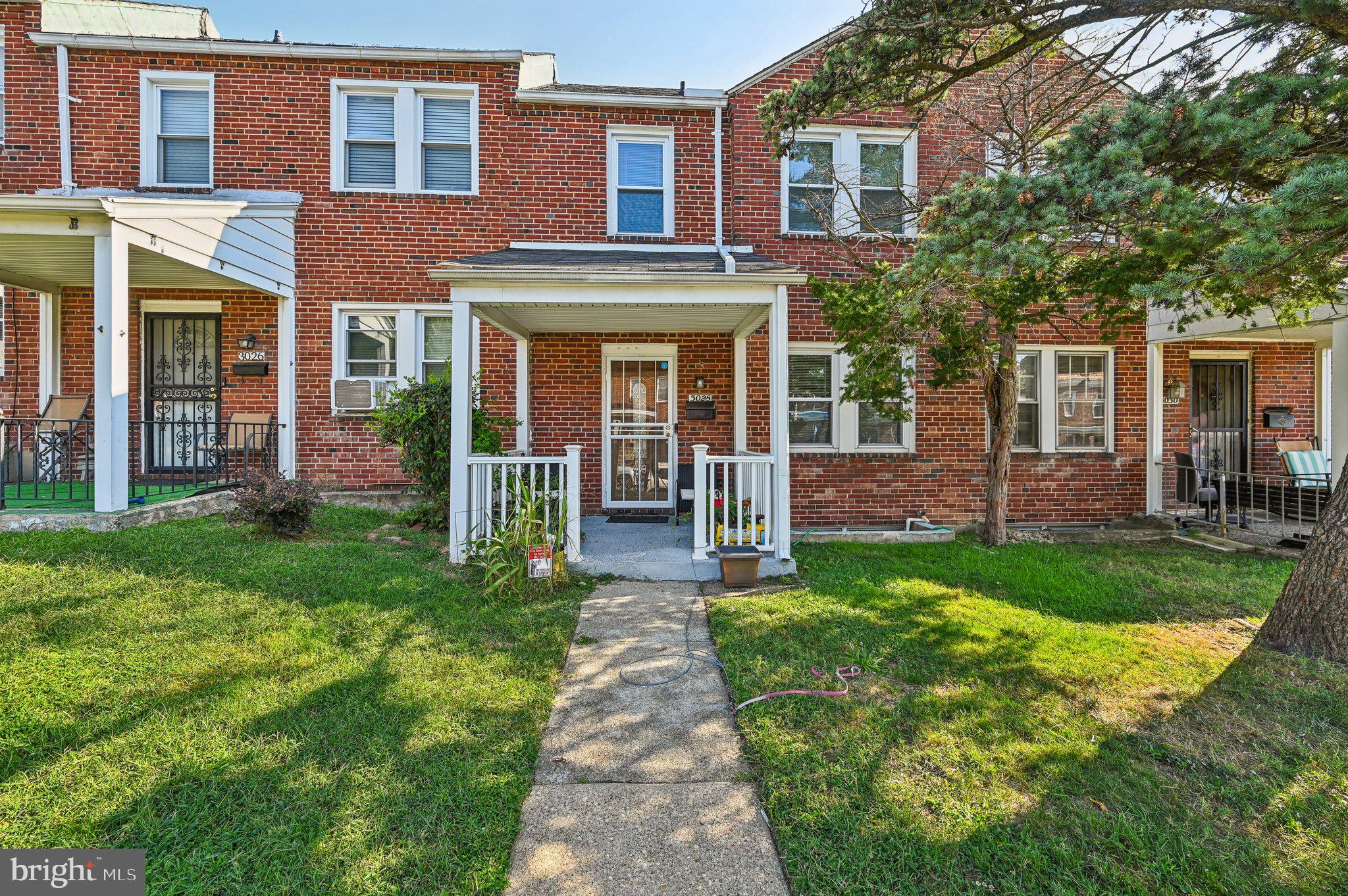 front view of a brick house with a yard