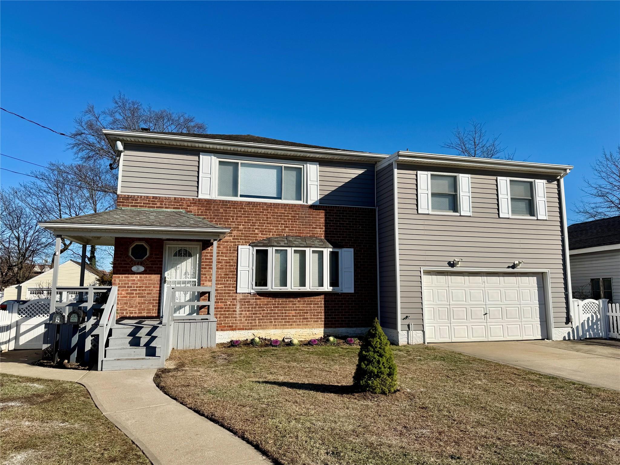 View of front of house with a garage and a front yard