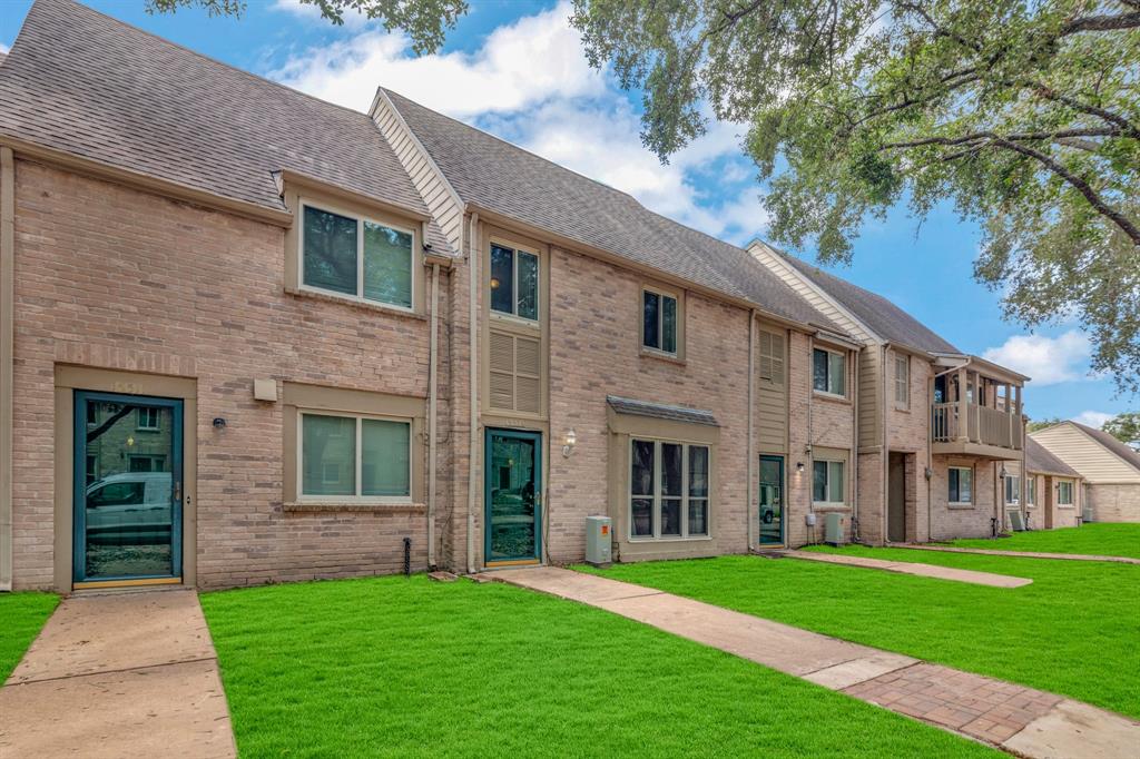 a view of a brick house with a yard