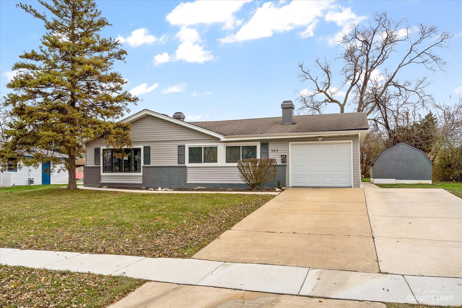 a front view of a house with a yard and trees