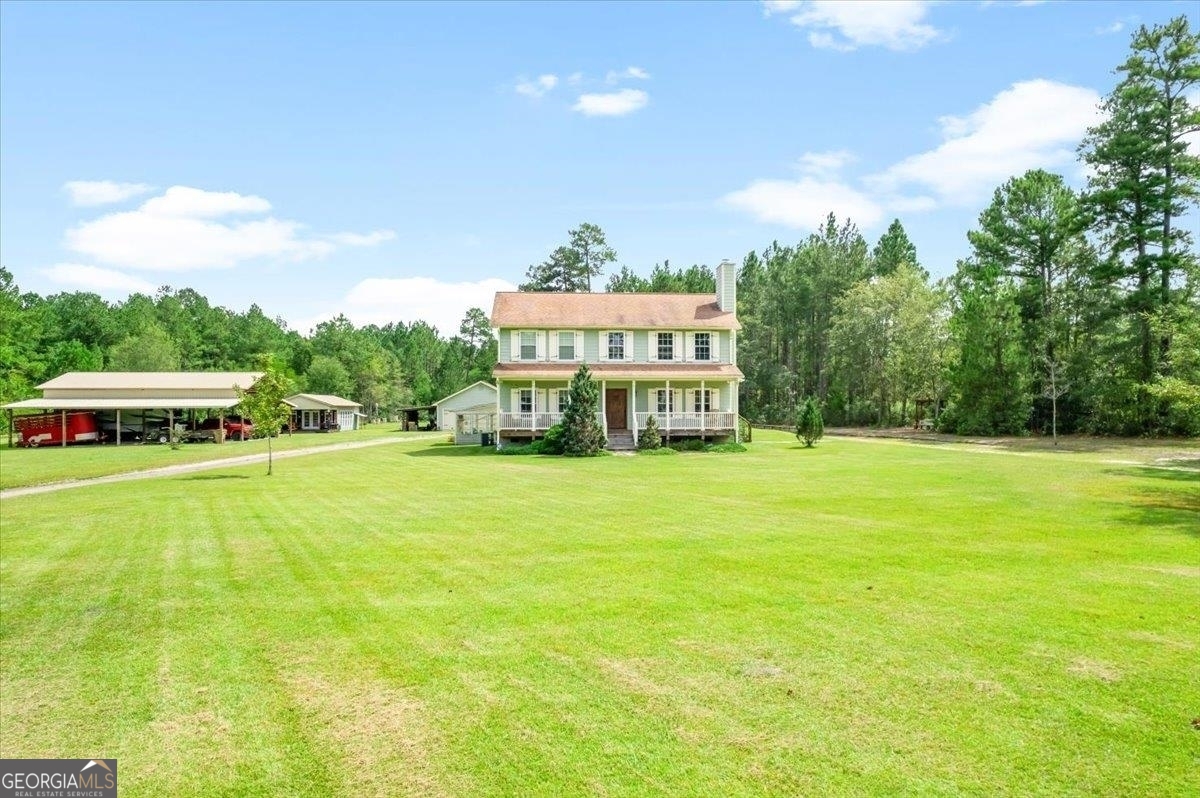 a view of a house with a big yard and large trees