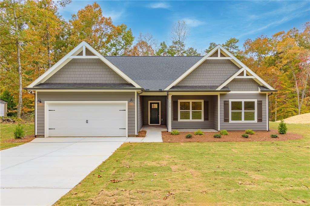 a front view of a house with a yard outdoor seating and garage