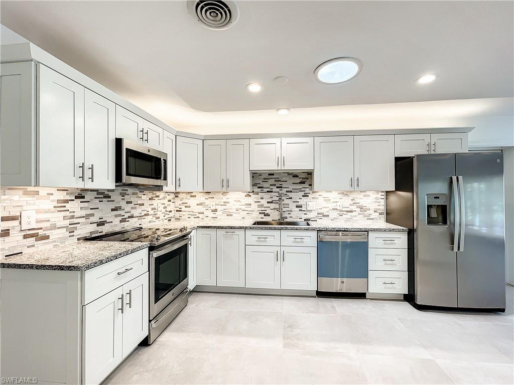 a kitchen with stainless steel appliances granite countertop a sink and stove top oven