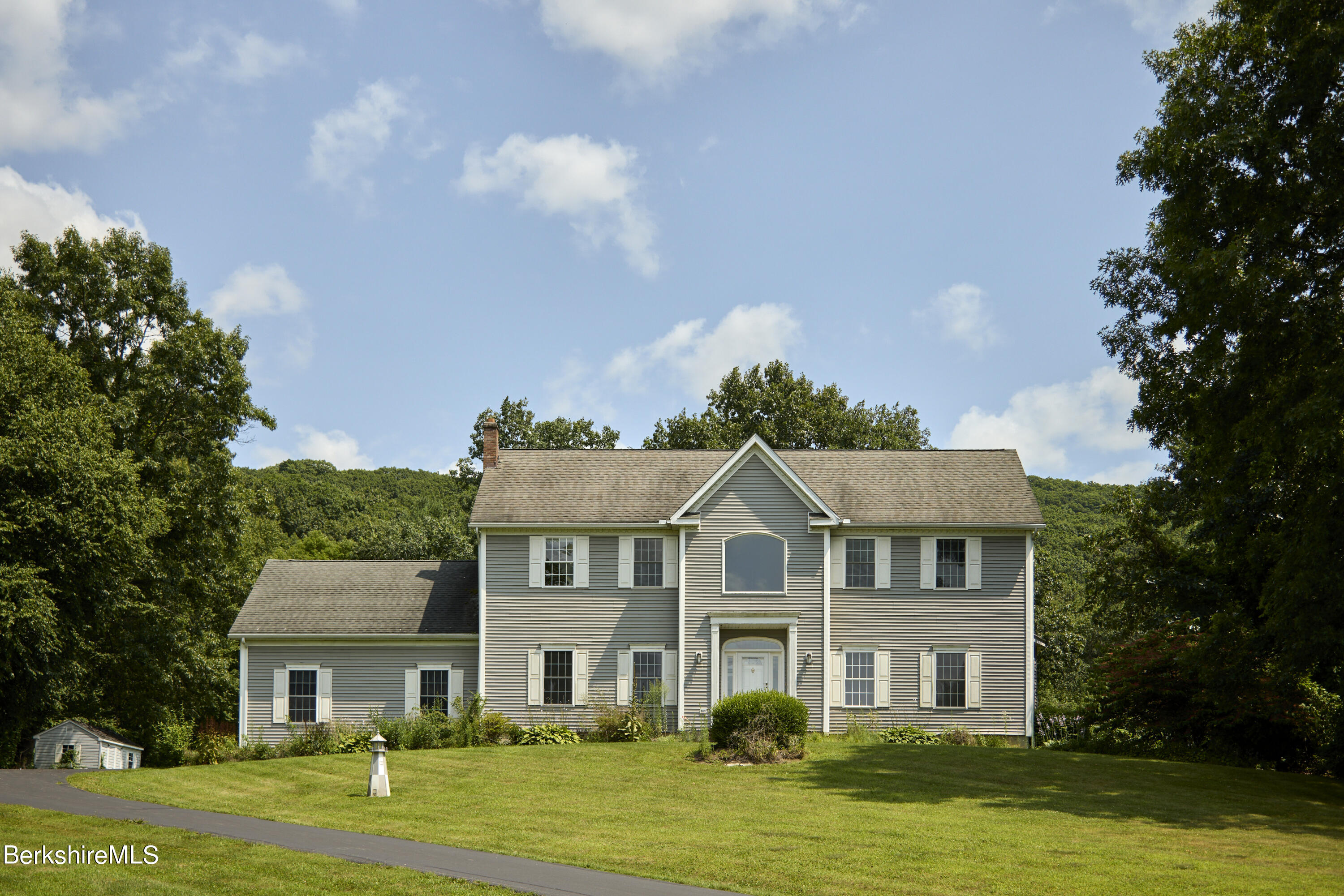 a front view of a residential houses with yard and green space