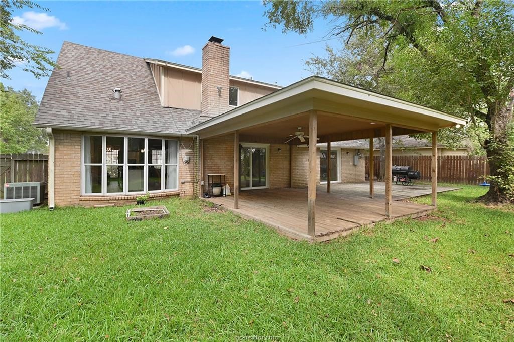 Back of property featuring a yard and ceiling fan