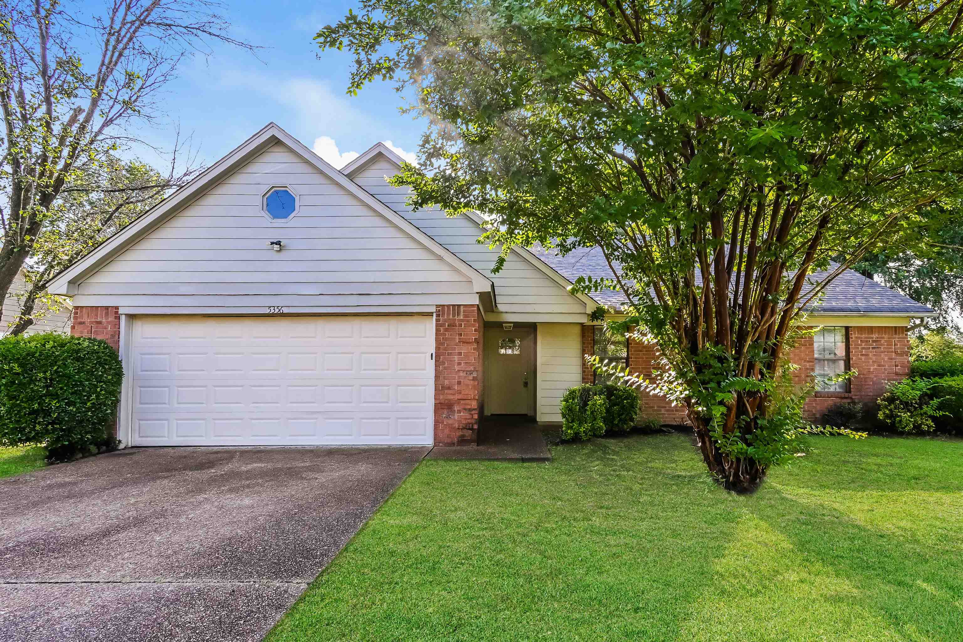 View of front of property with a garage and a front lawn