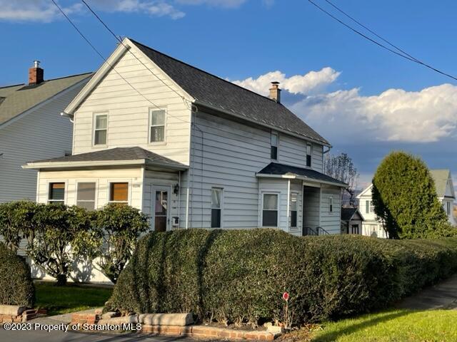 a view of a white house with a yard and potted plants