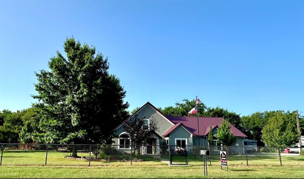 a front view of a building with trees and houses