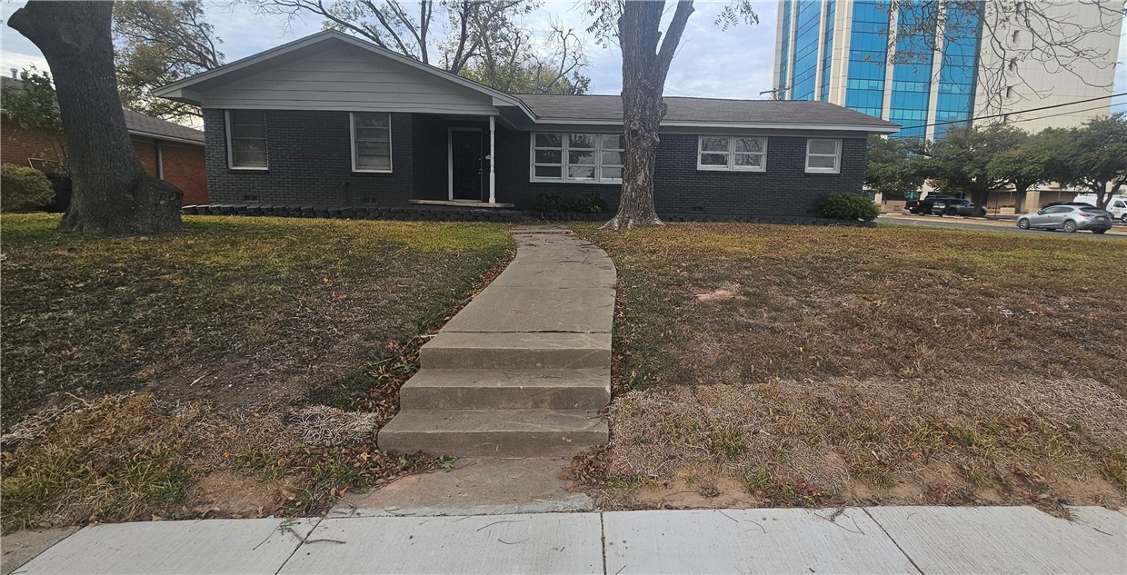 a front view of a house with a yard and trees