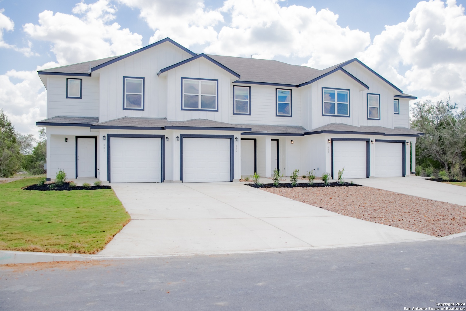 a front view of a house with a garden and garage