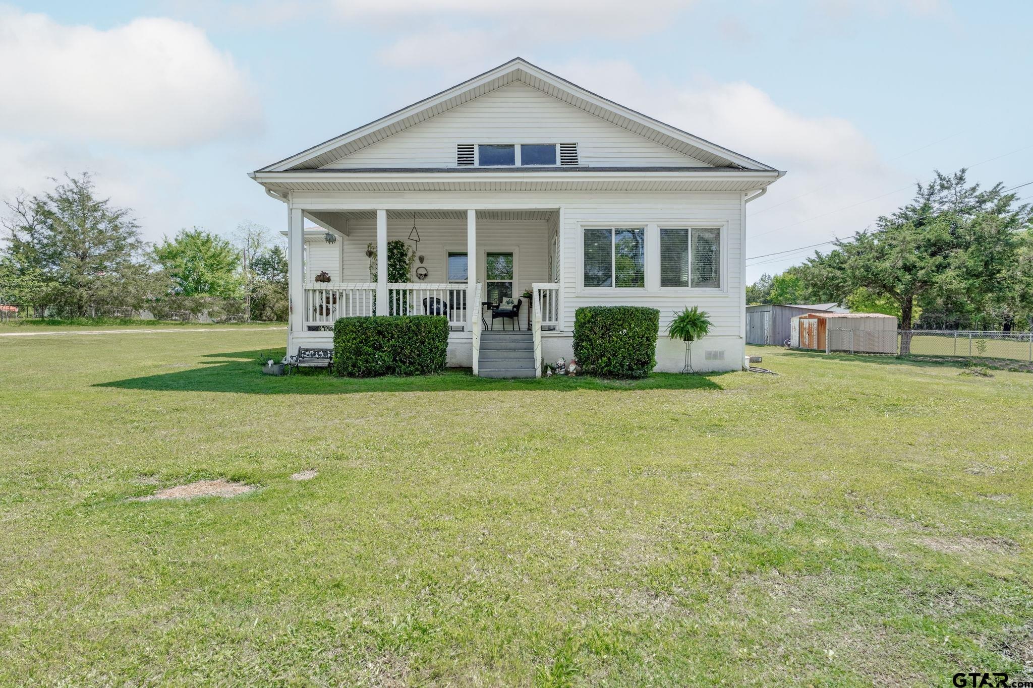 a view of a house with a yard and porch