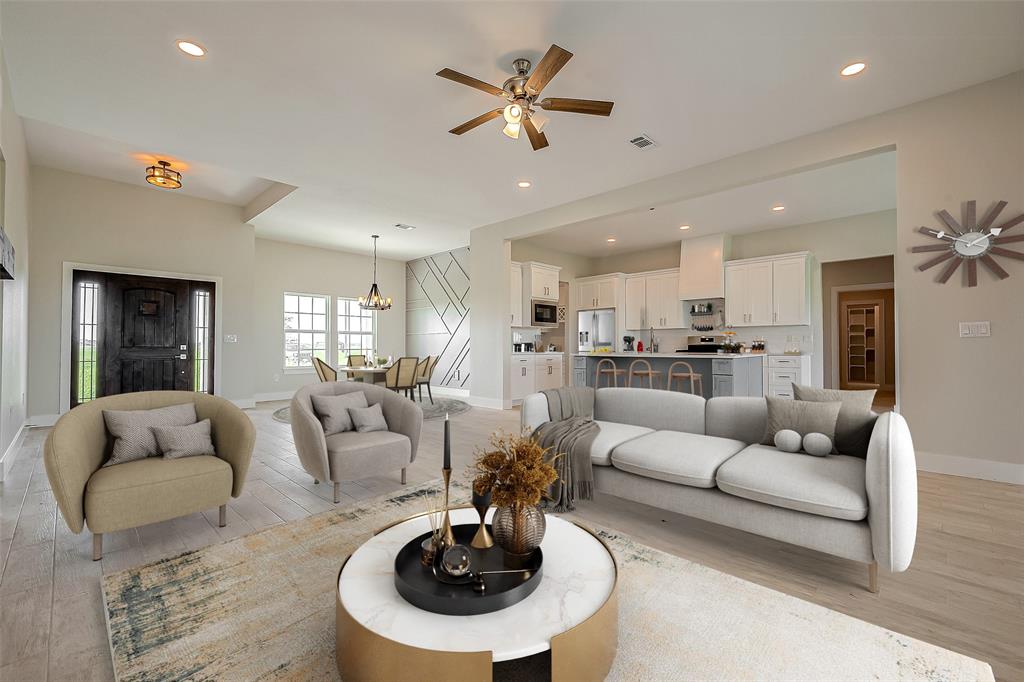 a living room with furniture kitchen view and a chandelier