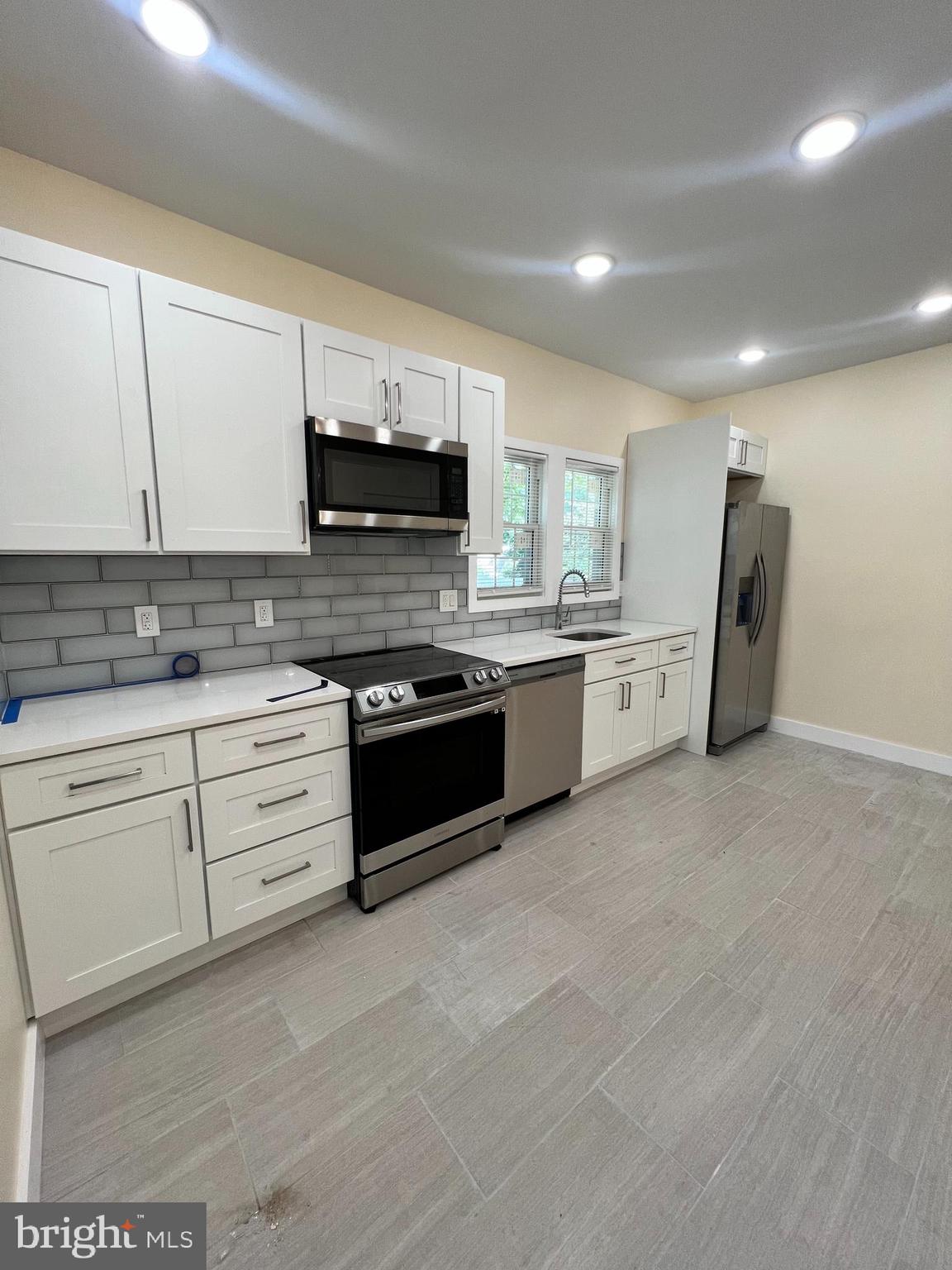 a kitchen with stainless steel appliances granite countertop a stove sink and cabinets