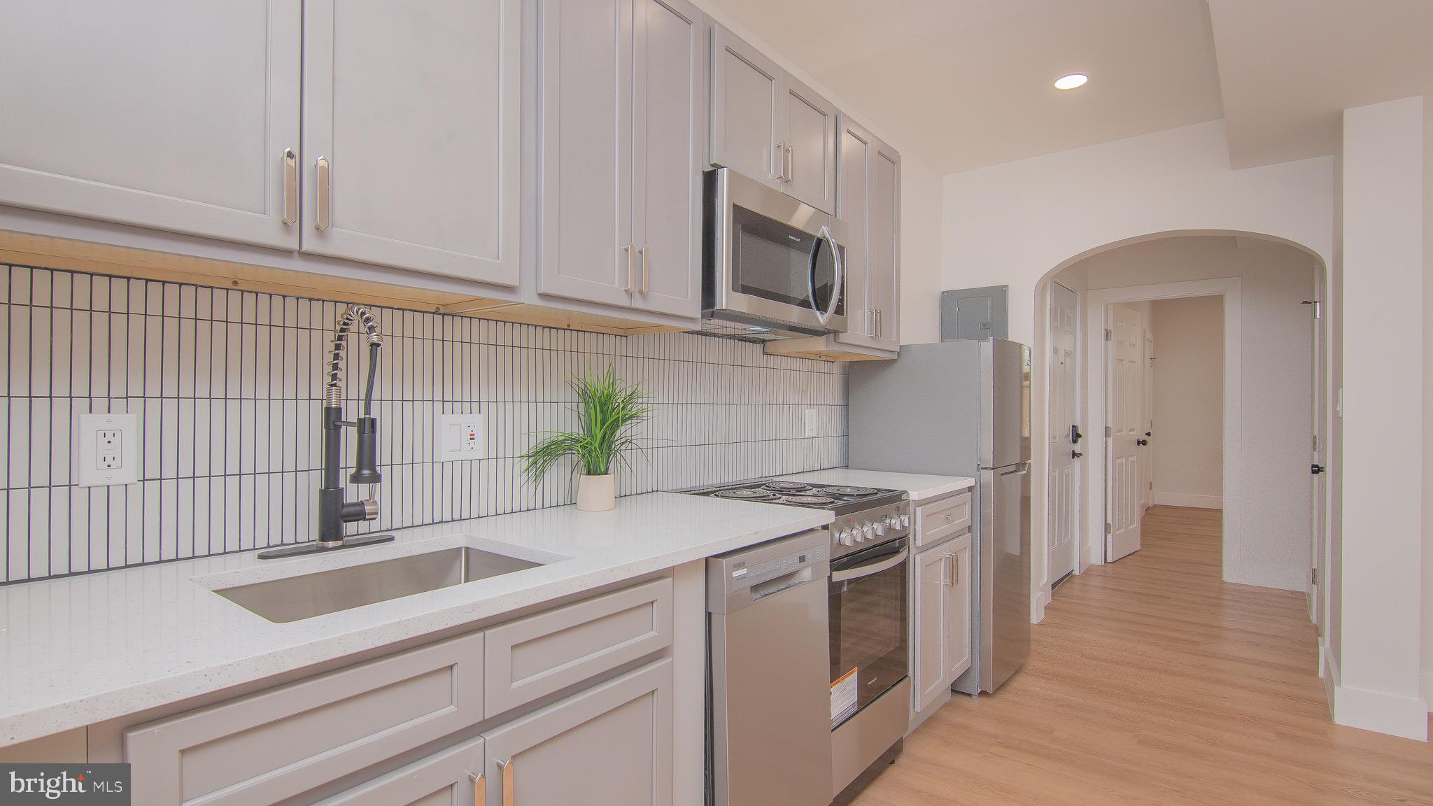 a kitchen with stainless steel appliances granite countertop a sink a stove and a refrigerator