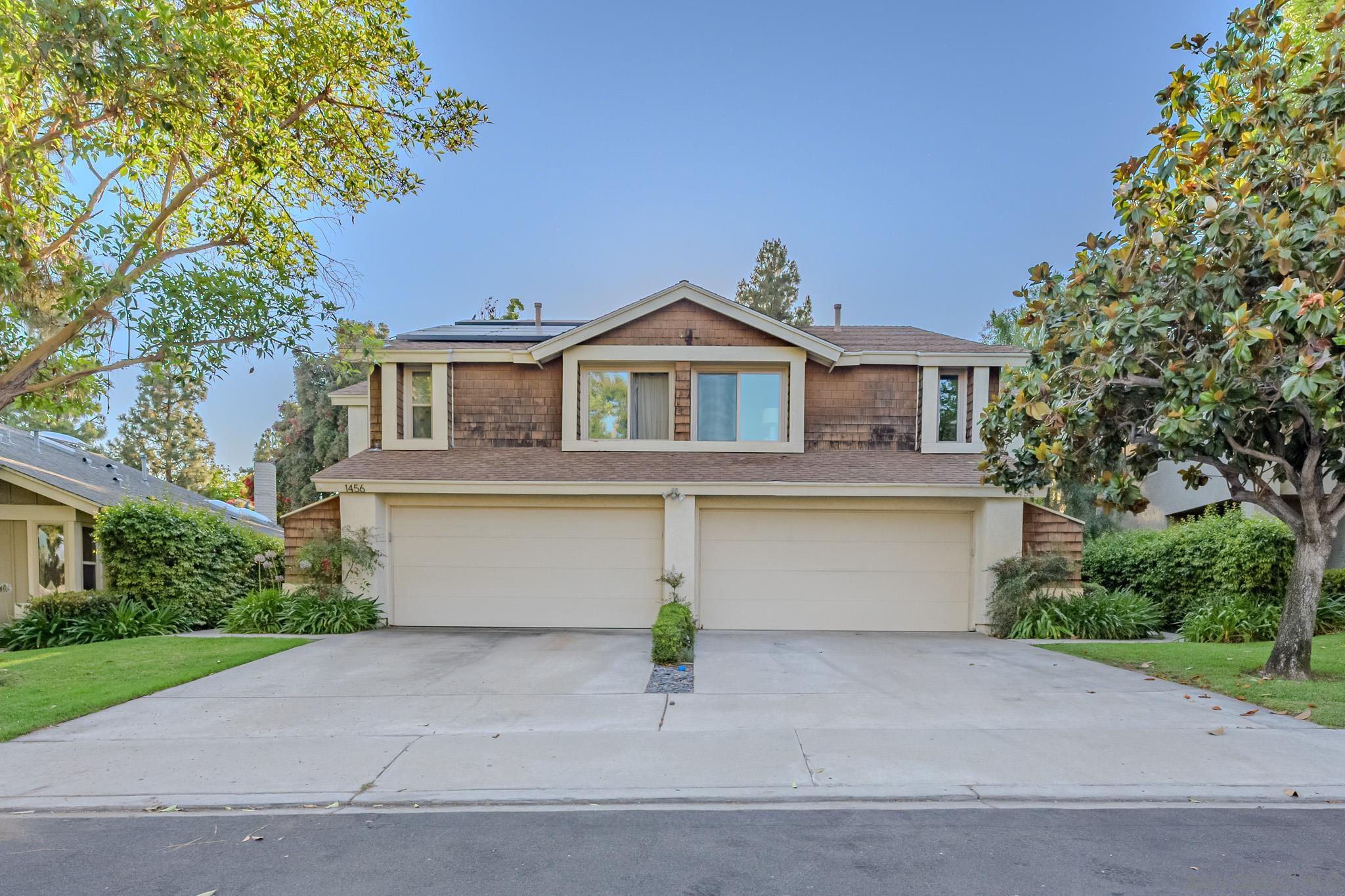 a front view of a house with a garden and garage