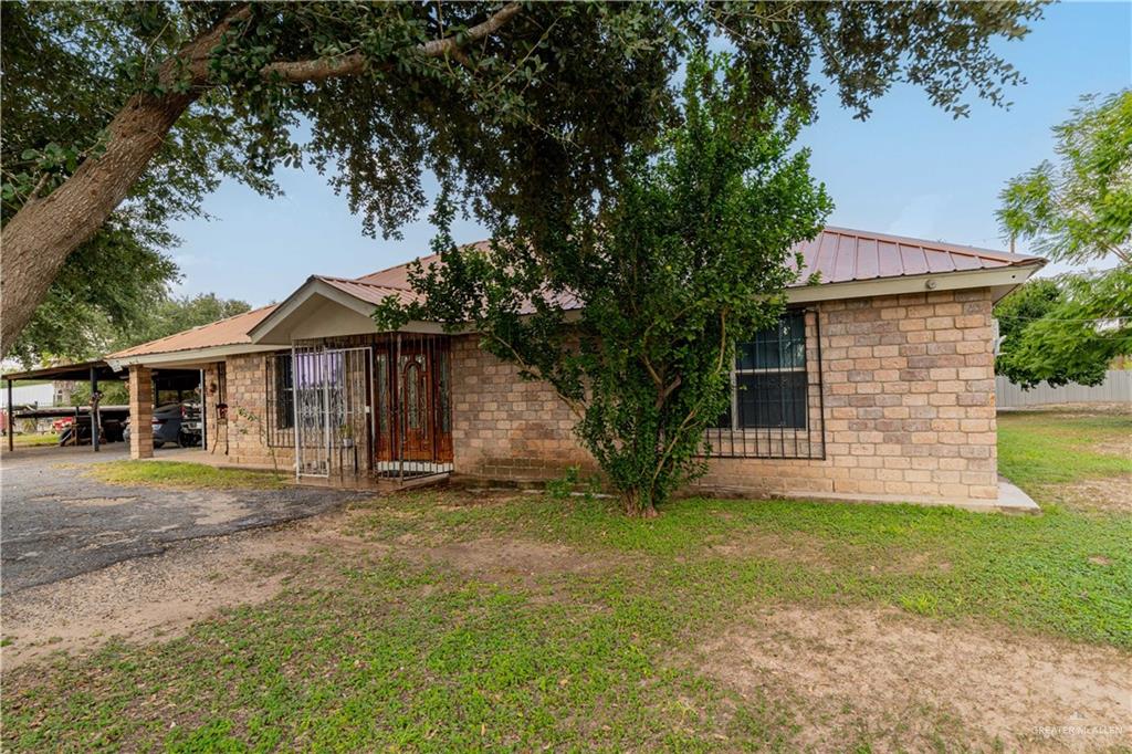 View of front of home featuring a front lawn and a carport