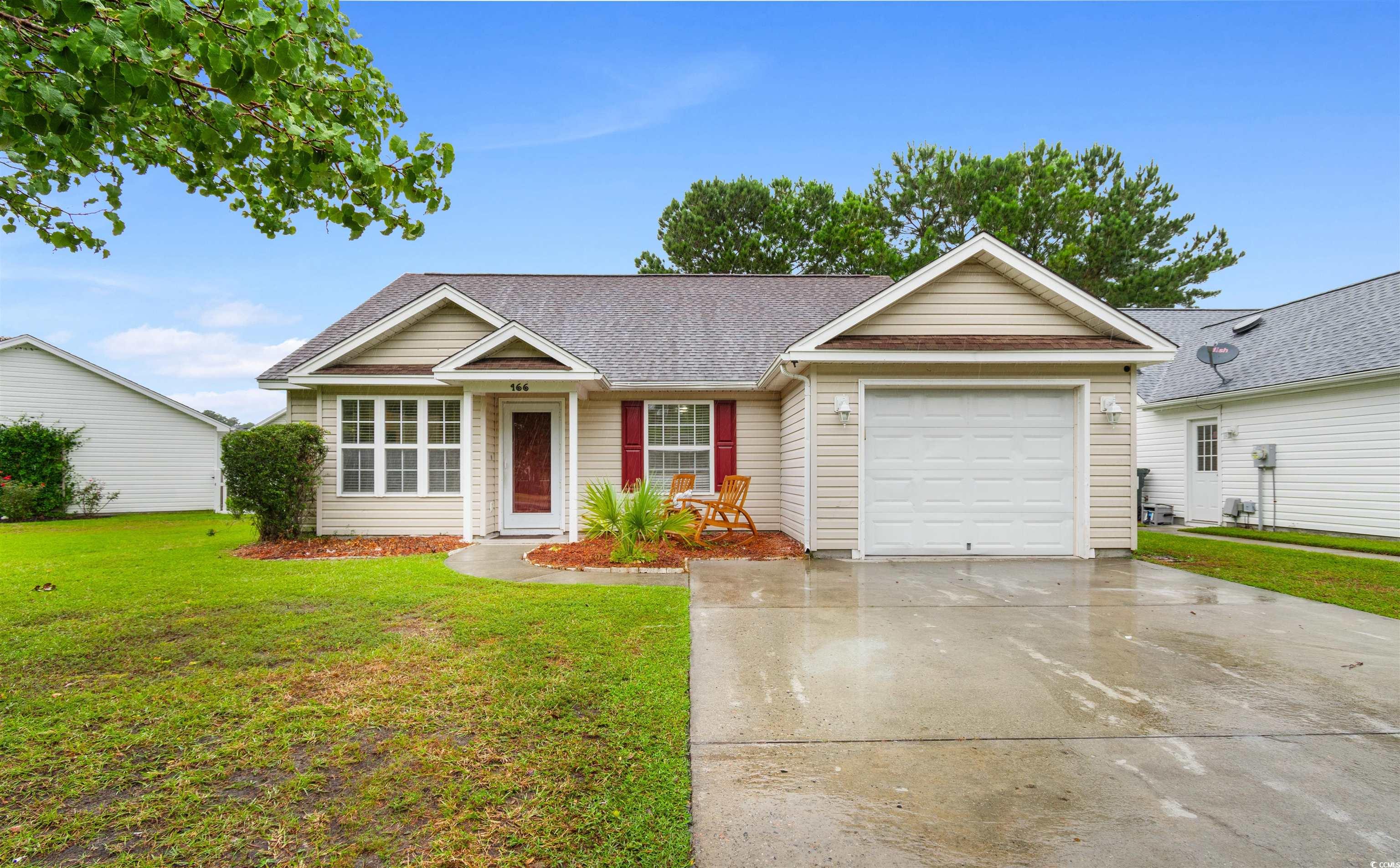 Ranch-style home featuring a garage and a front ya