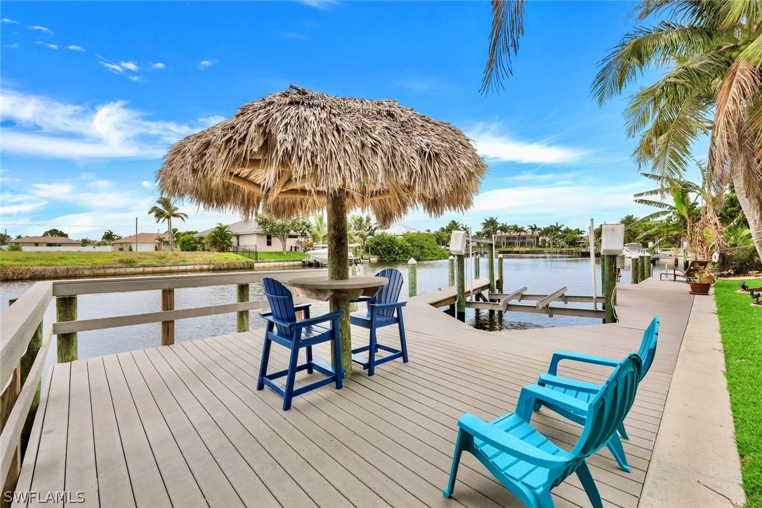 a view of a roof deck with table and chairs under an umbrella with wooden floor