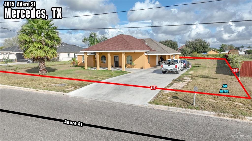 View of front of property with a front yard and a carport